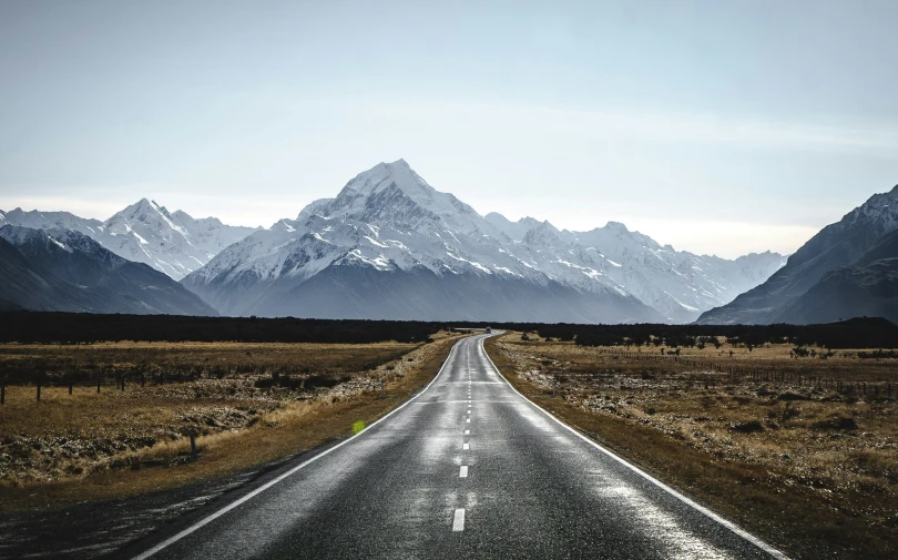 the road is straight ahead in front of the mountain range