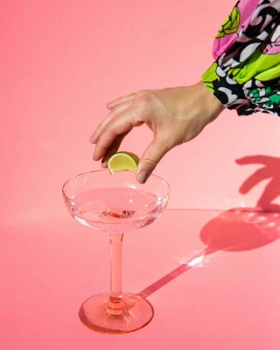 a woman is holding a lime and a cocktail