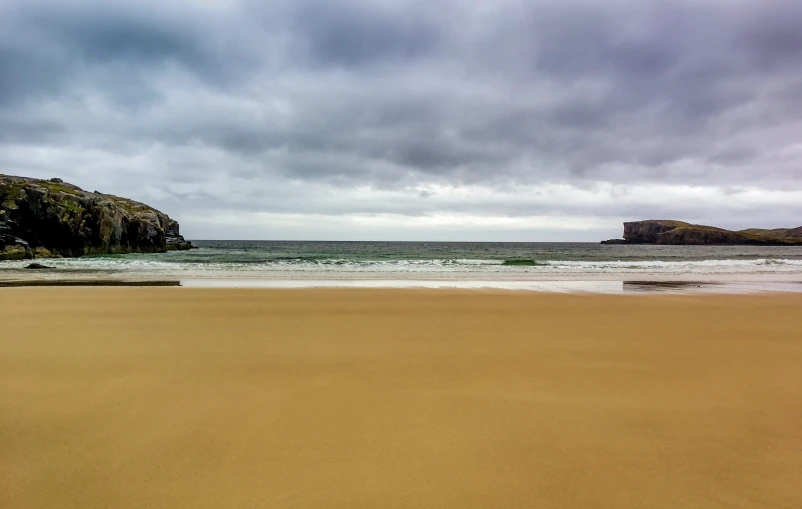 the beach on an overcast day has long shadows