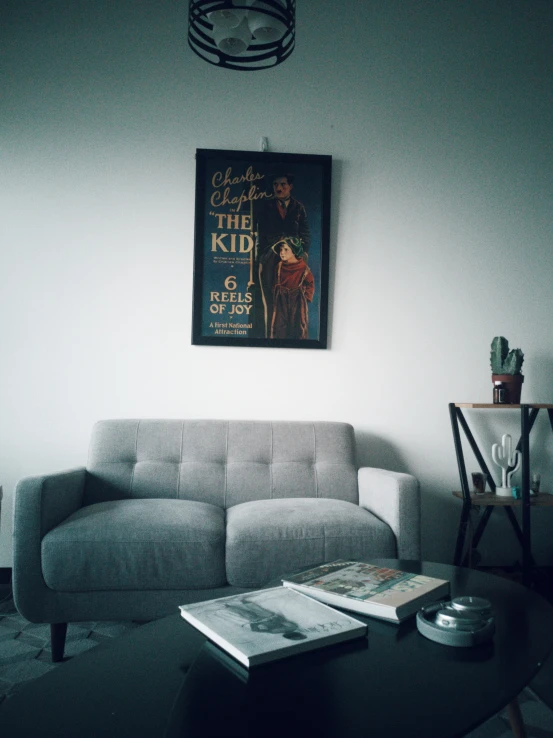 a living room with a sofa and posters on the wall