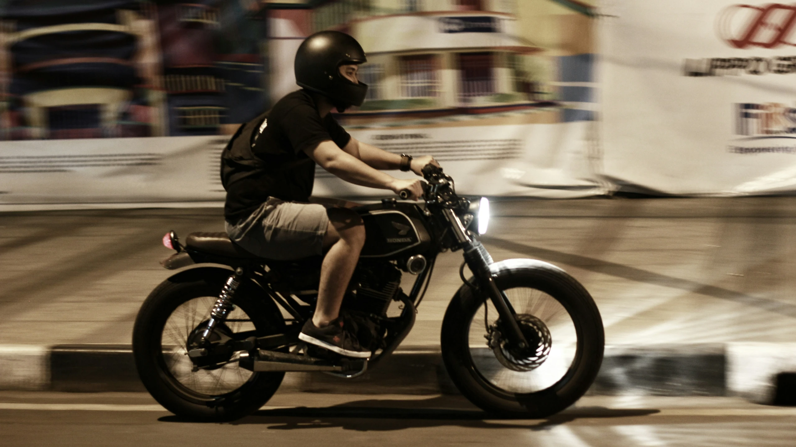 man sitting on the motorcycle going down a street