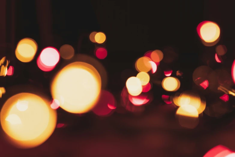 the blurry image of street lights has many color dots