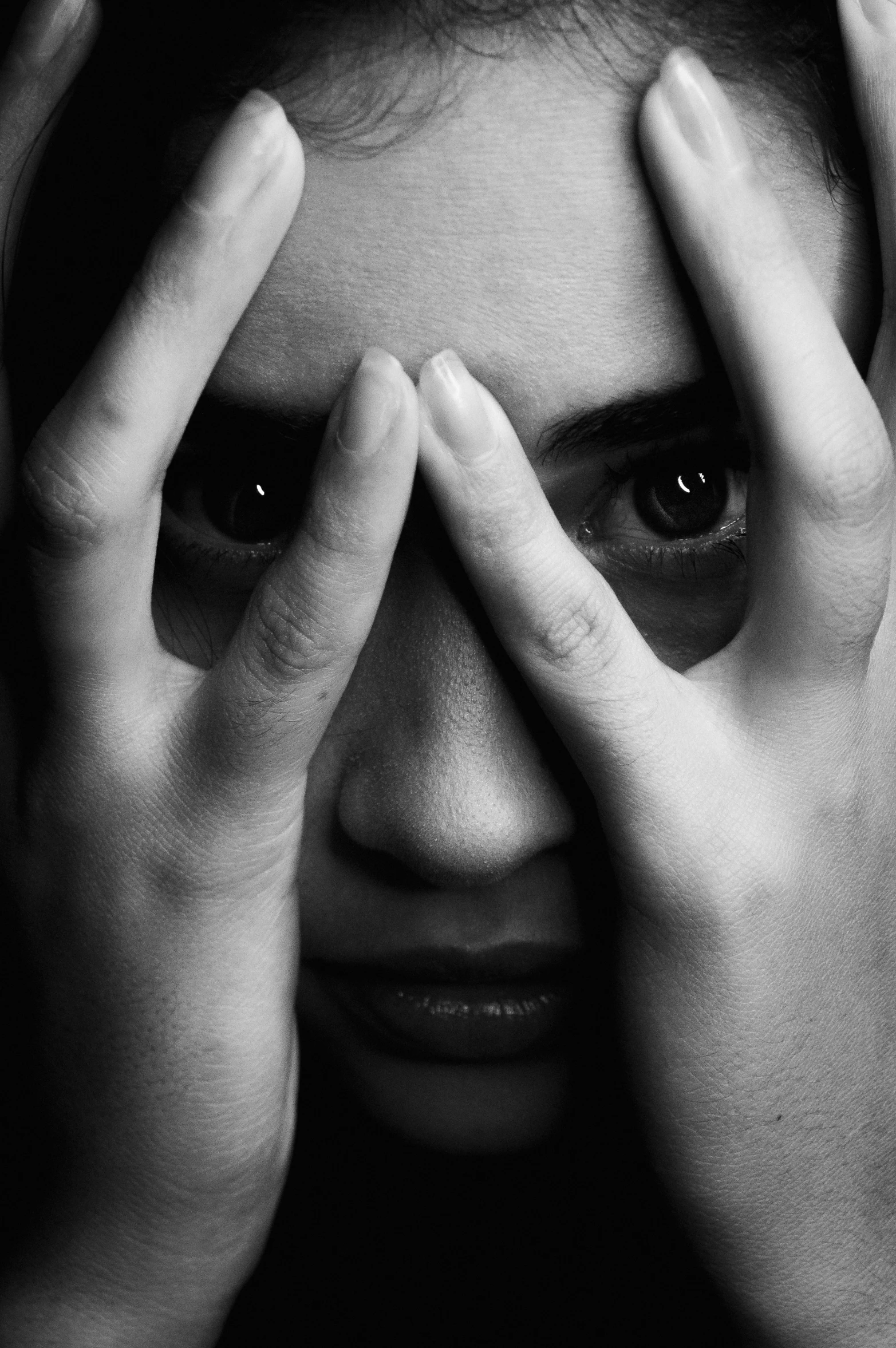 a young woman covers her eyes with hands