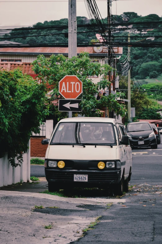 an alto car is parked next to a street sign