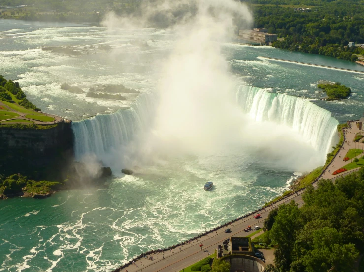 a boat that is floating in the water next to a falls