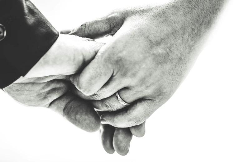 two people holding hands in a black and white po