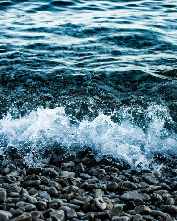 a close up of waves crashing against rocks