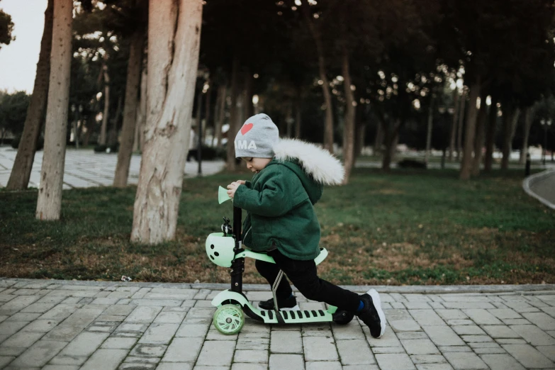 a child on a scooter playing on the sidewalk