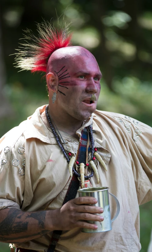 a man with mohawk hair holding onto a can