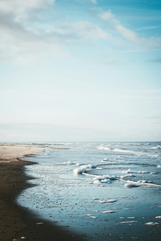 a group of people walking along a beach with waves