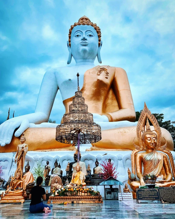 a large white buddha statue sitting in the middle of a lake