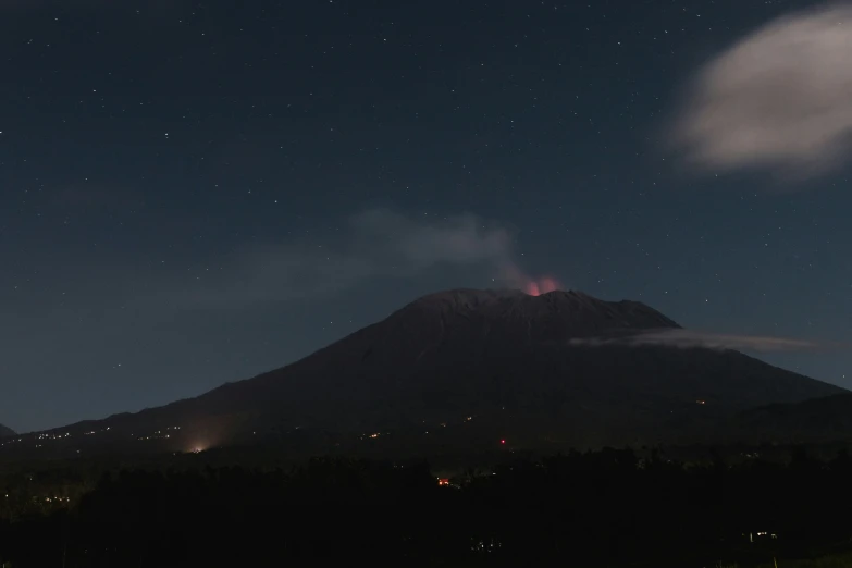 a hill with mountains and a night sky