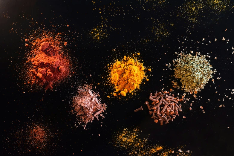 several colorful powdered objects spread across a black surface
