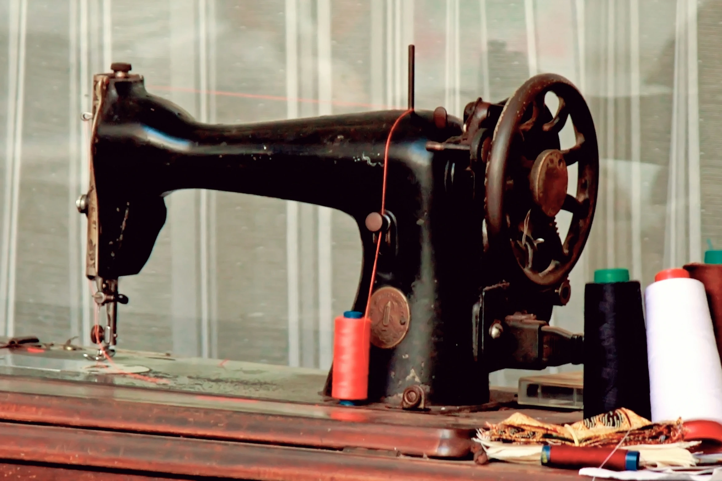 a sewing machine sitting next to a bunch of thread