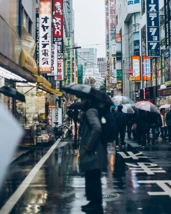 a city street filled with lots of people holding umbrellas