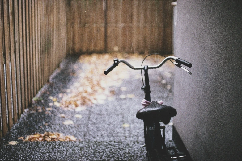 a bicycle parked on the pavement beside a wall