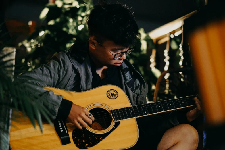 a man holding a guitar and staring at his watch