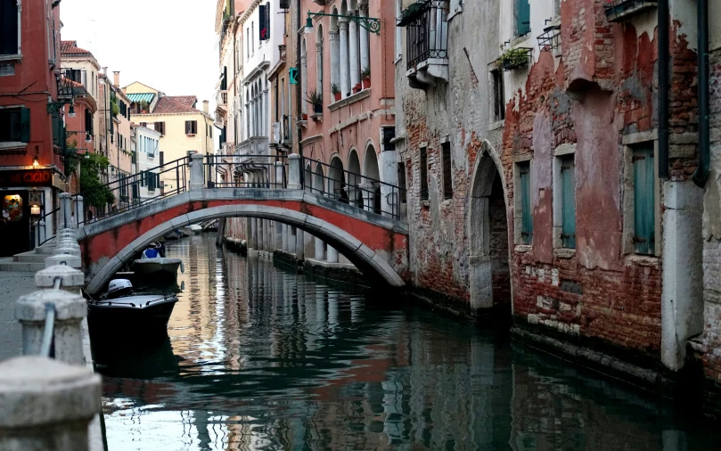 a small boat traveling along a canal in the city