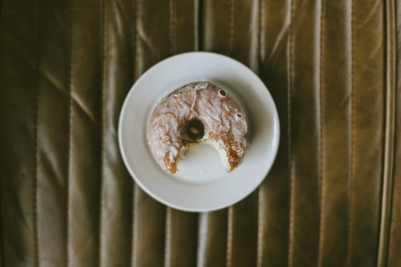 a half eaten doughnut on a white plate