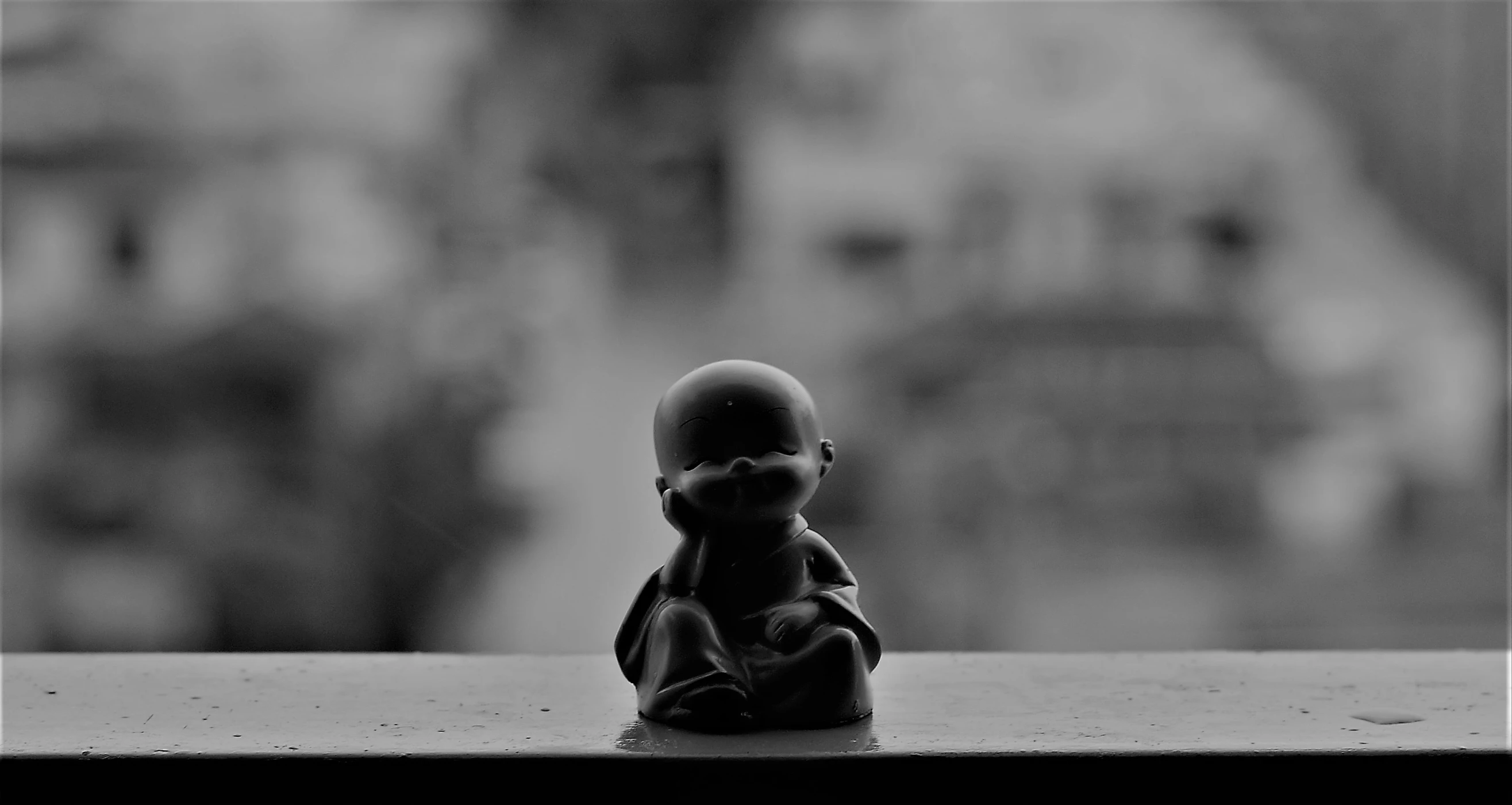 an old figurine sits on a windowsill