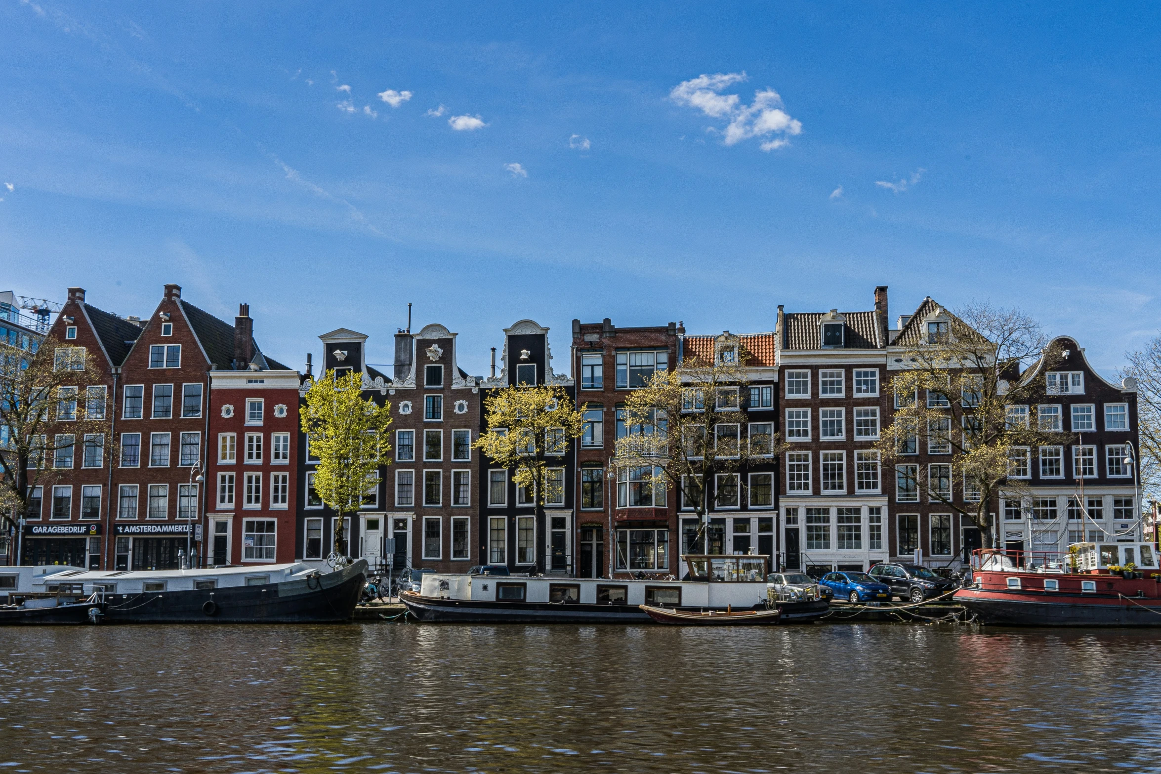 a group of buildings with boats on the river in front of them