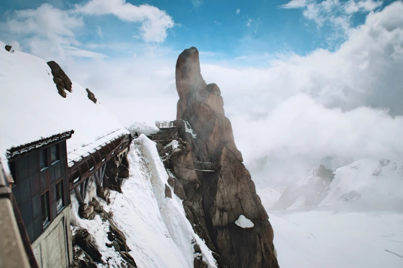 the mountain side house is covered with white snow