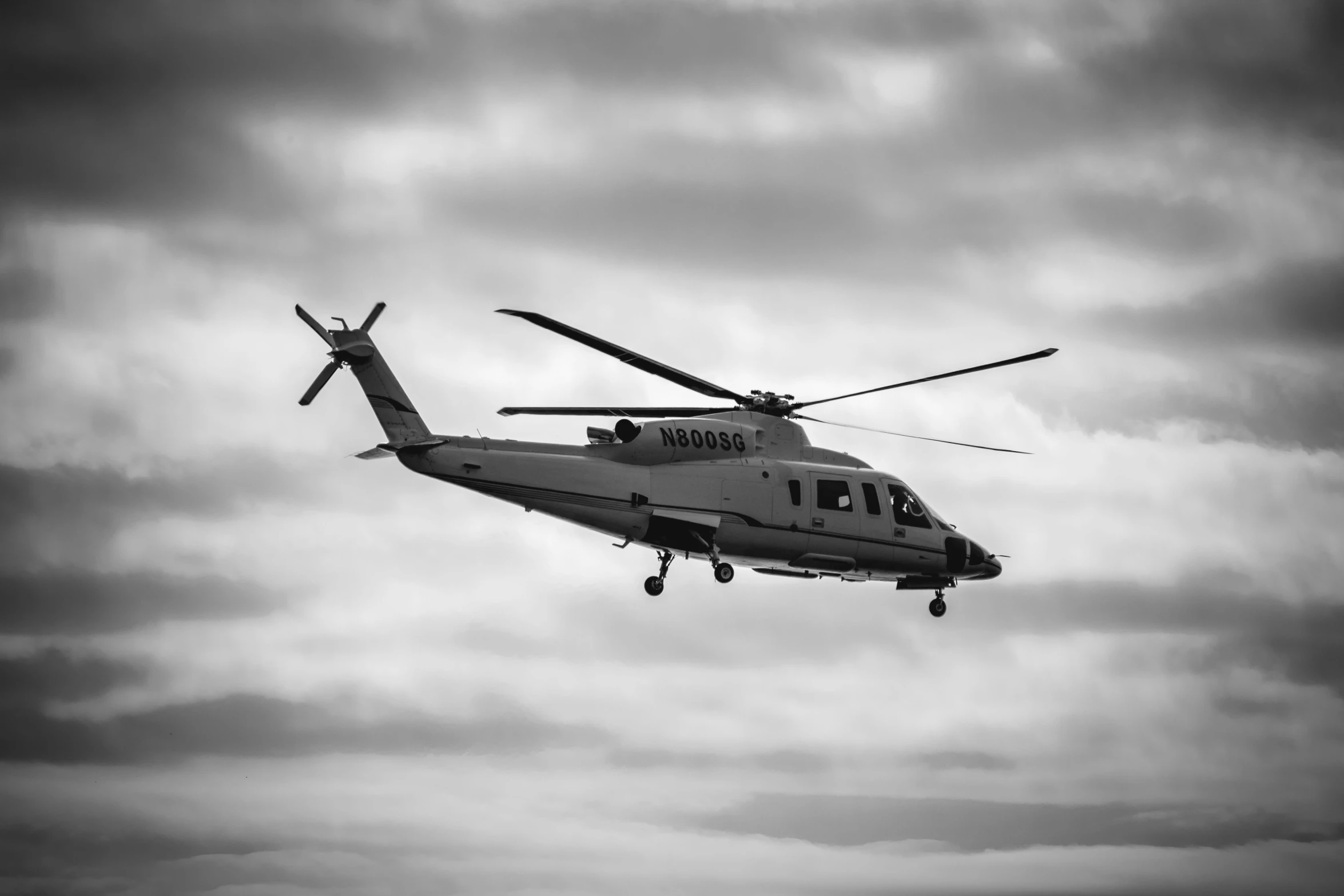 the large helicopter is flying through the clouds