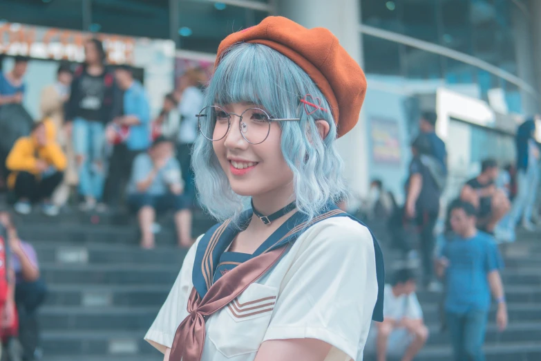 a woman with blue hair and glasses smiling