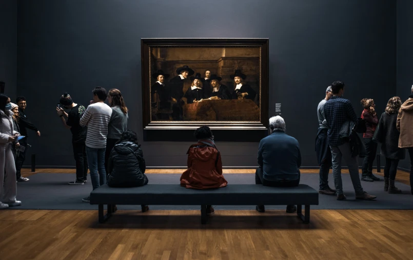 a group of people looking at art in a museum