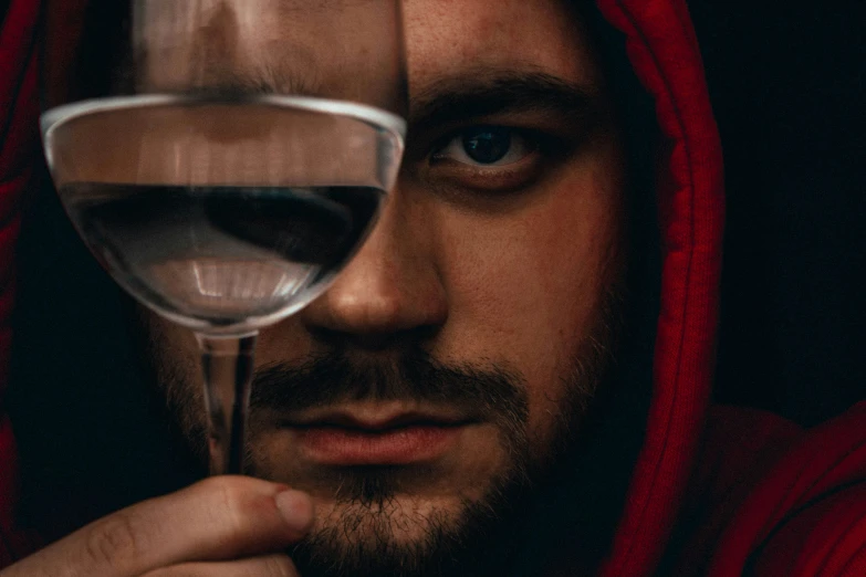 man looking intently at glass of wine