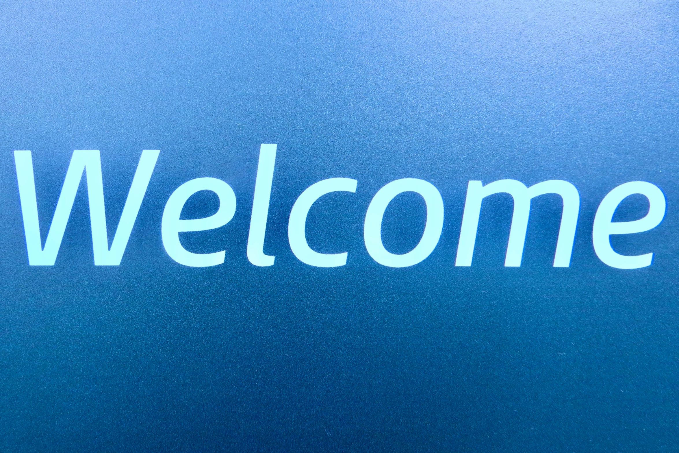 a metal sign that says welcome on it