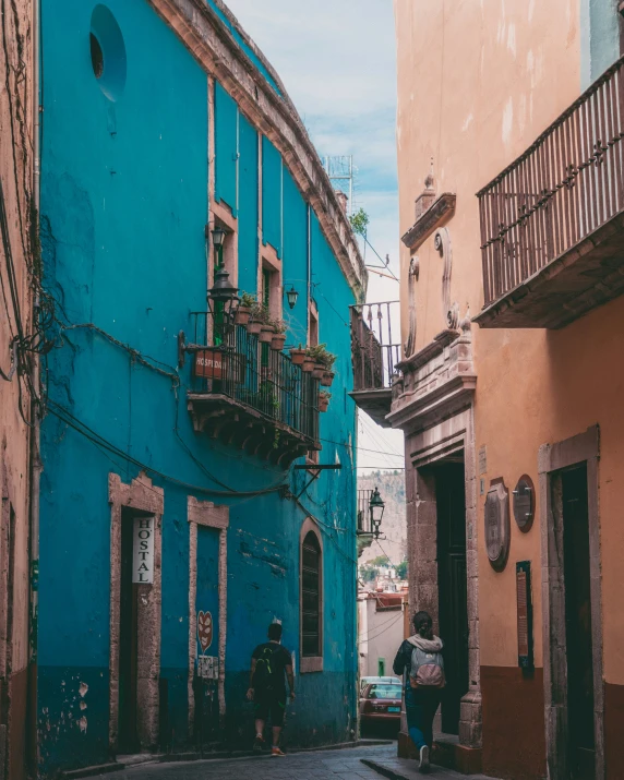 a group of people are walking down an alley way