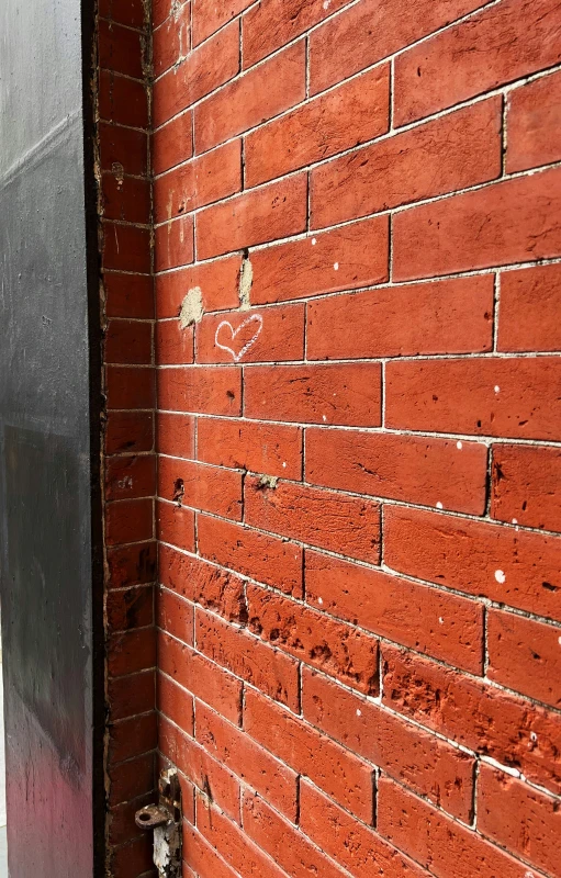 a small metal box is on a brick wall