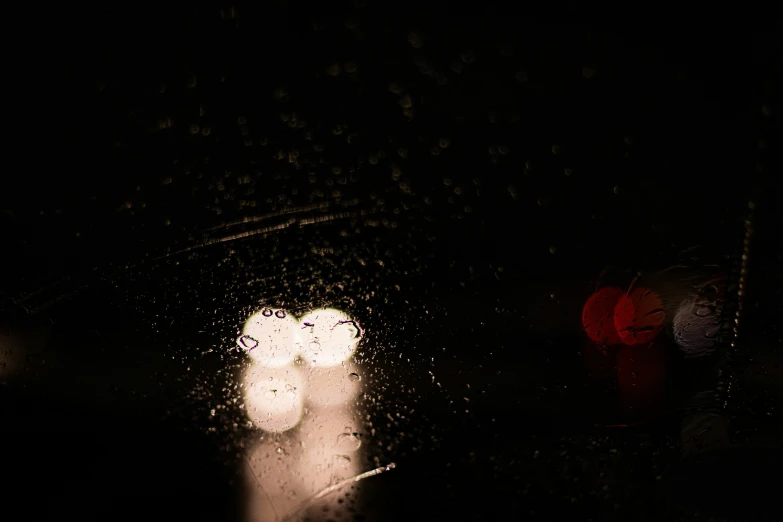 street lights reflected in the wet windshield of a vehicle