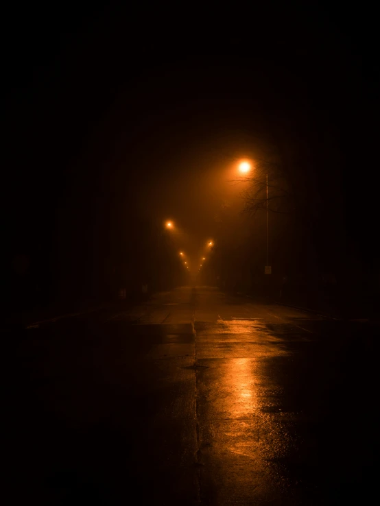 a dark street at night with a few traffic lights