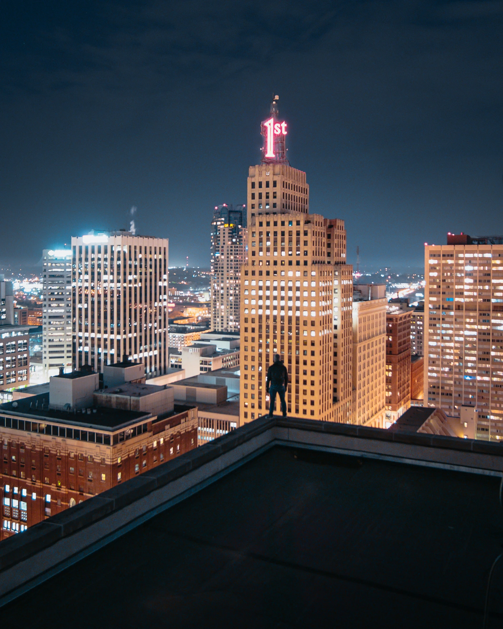 a person on top of the building staring at the night sky