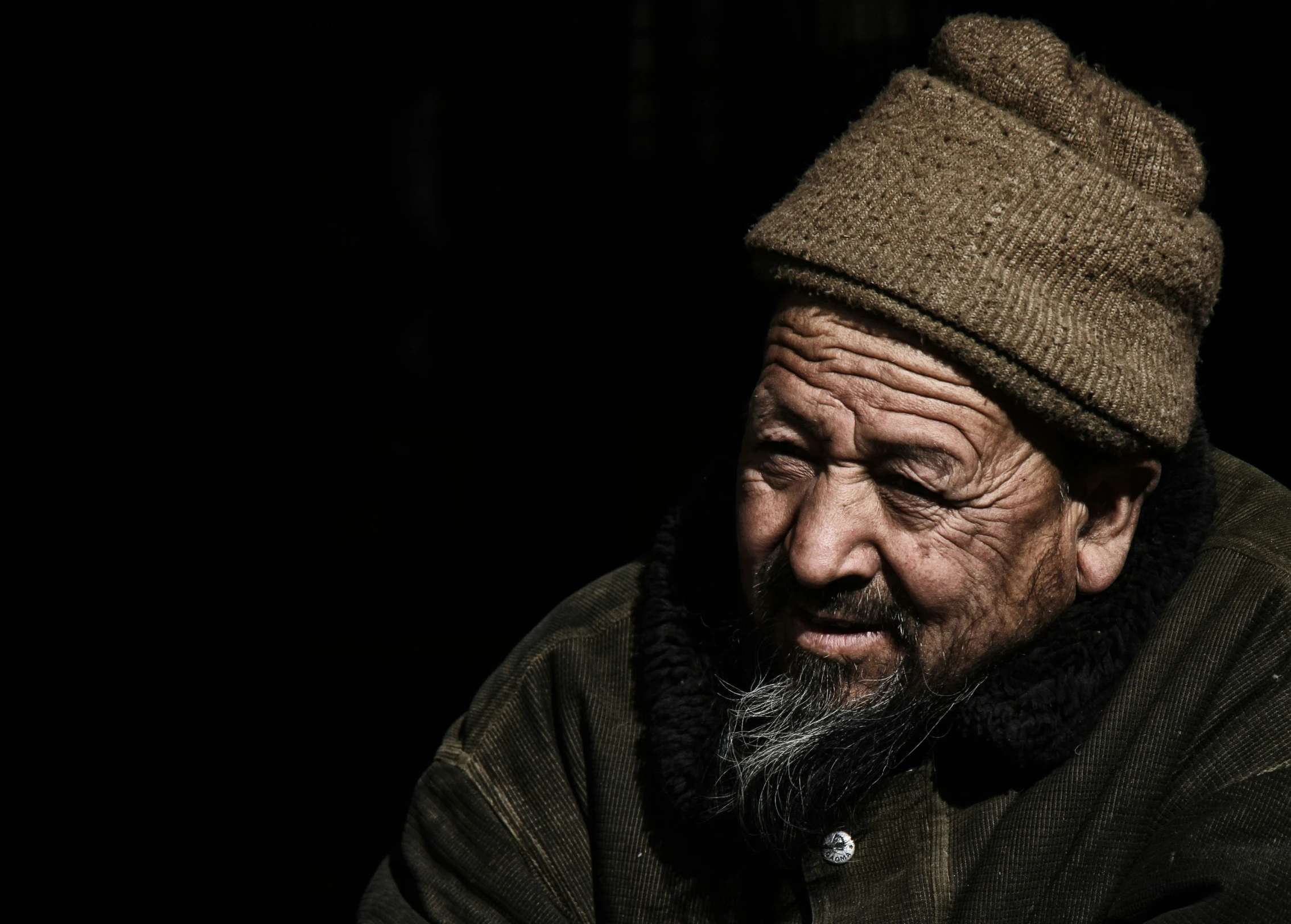 an old man is wearing a hat and a scarf