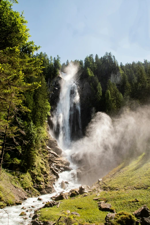 mist covers the waterfall in the mountains below