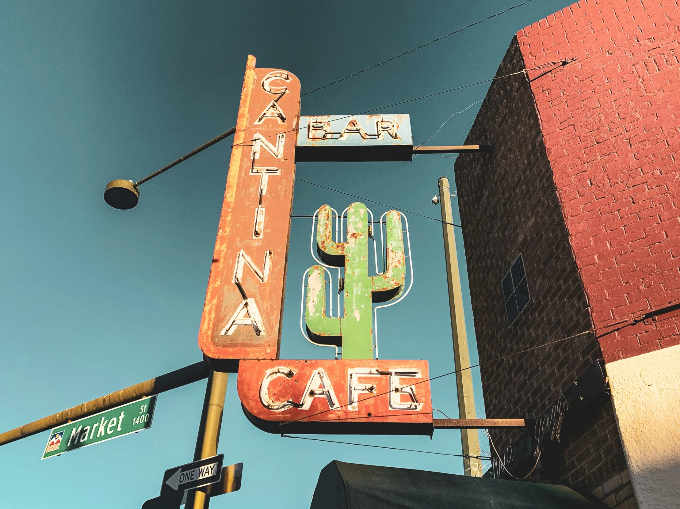 a colorful neon sign sitting above a city street