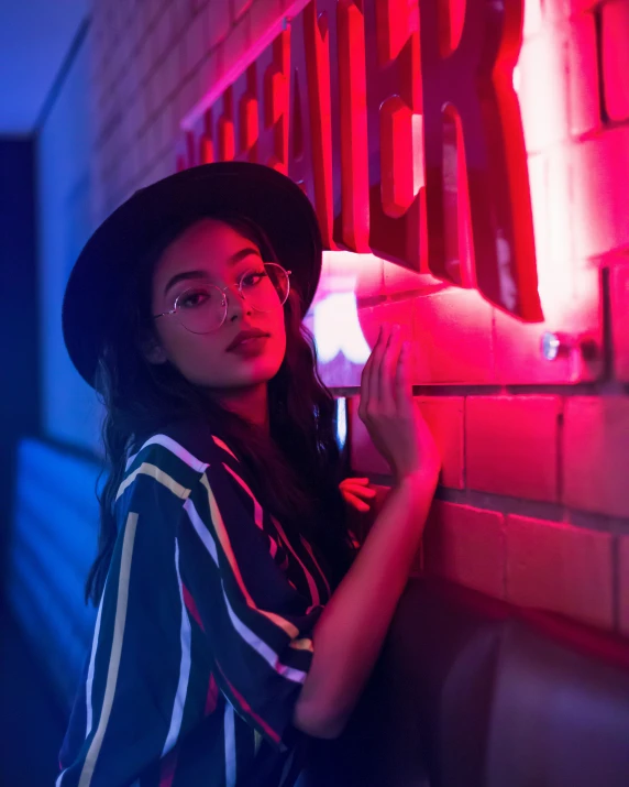 a woman standing next to a brick wall