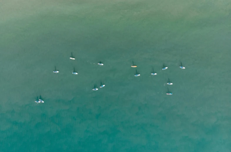 several boats are sailing in the water off shore