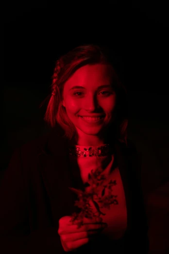 woman with red lighting smiling at camera