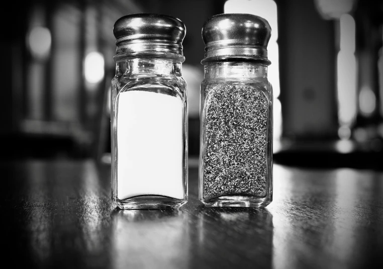 two jars full of salt sit on a table