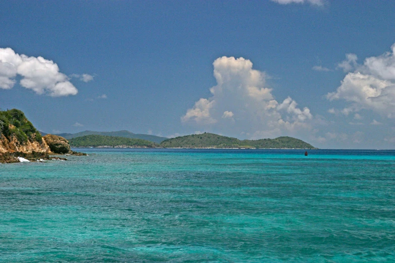 clear water with green hills in the background