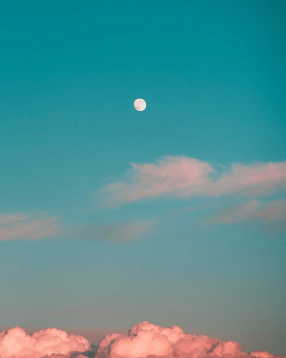 the moon is shown above some clouds