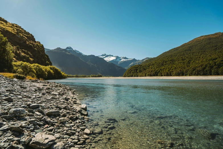 an expansive mountain and river scene taken from the shores