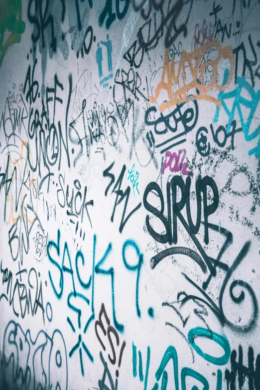 a wall covered in graffiti of various different colors