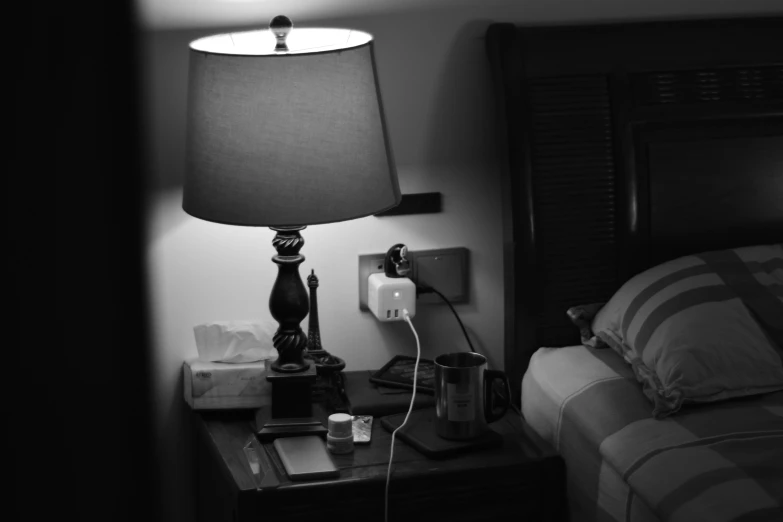 a lamp sits next to a night stand on a nightstand