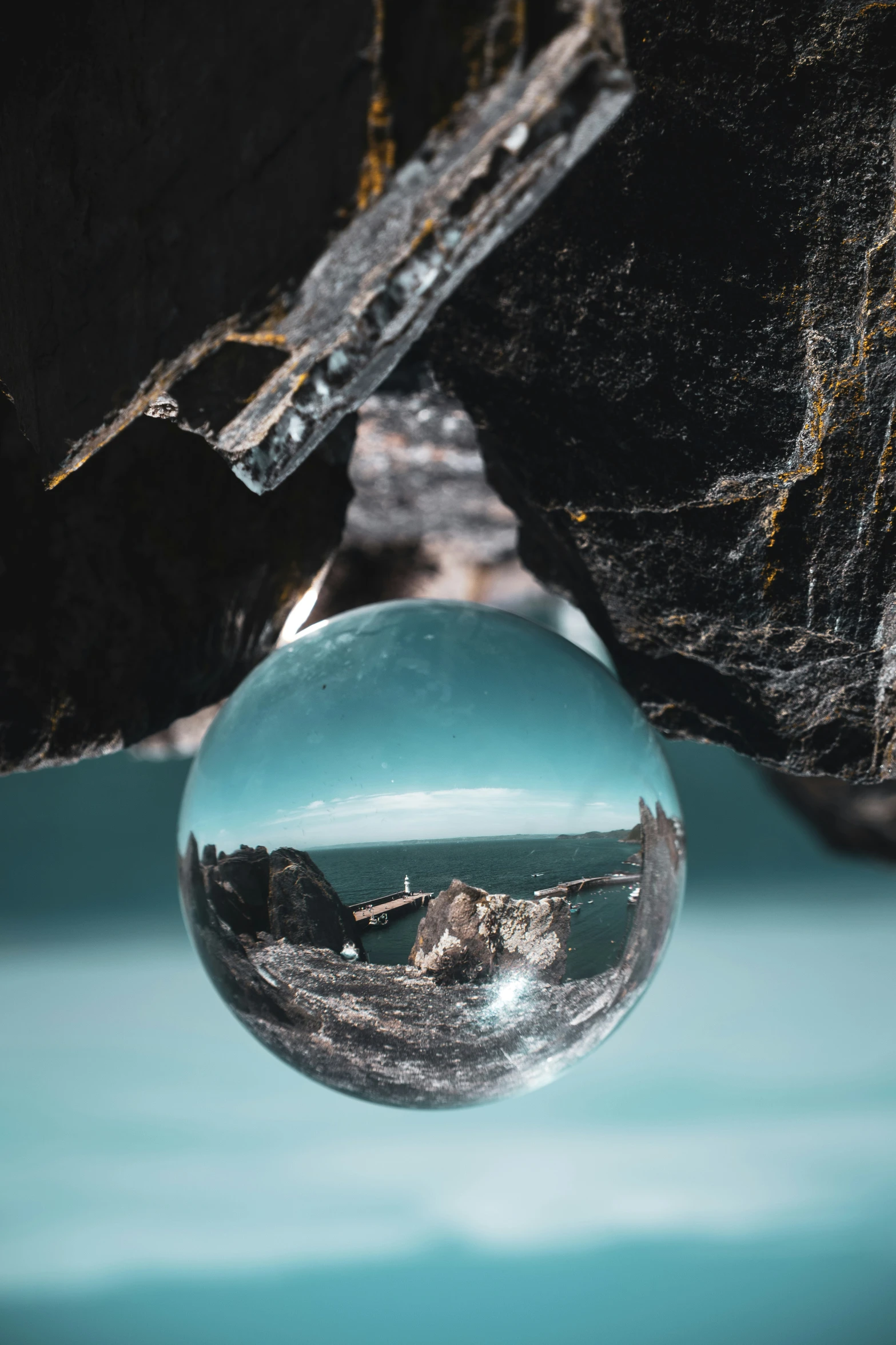 the marble ball is laying on top of a piece of rock