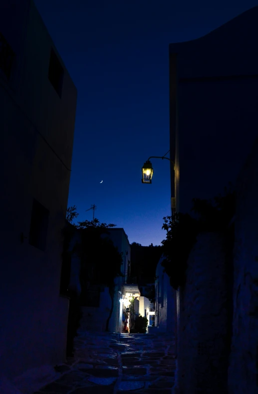 the alley between two buildings has dark lights